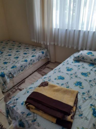 1 dormitorio con 2 camas y ventana en Erdek Özlem Pansiyon en Erdek