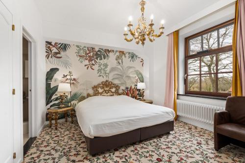 um quarto com uma cama e um lustre em Hotel Torenhof em Sint-Martens-Latem