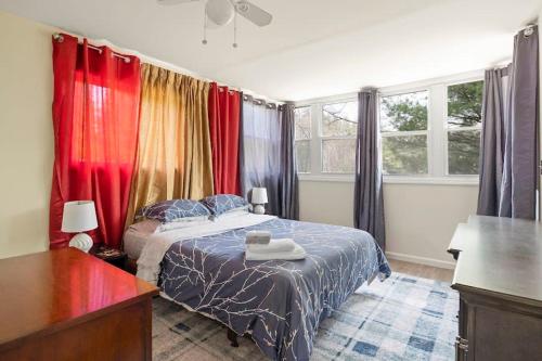 um quarto com uma cama com cortinas coloridas em Relaxing 2BR Lakehouse by CozySuites em Copake