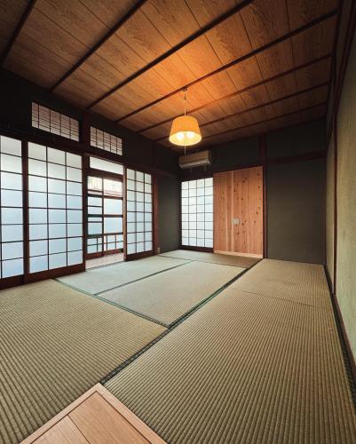 an empty room with a large room with windows at 敷島旅館 in Saijo