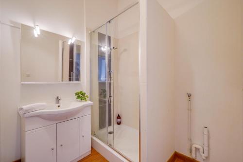 Un baño blanco con lavabo y ducha. en Le Yellow - Centre de Bordeaux, en Burdeos
