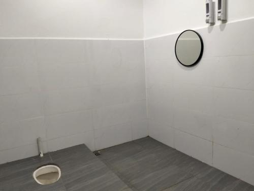 een badkamer met een spiegel en een toilet bij MTF Homestay in Baling