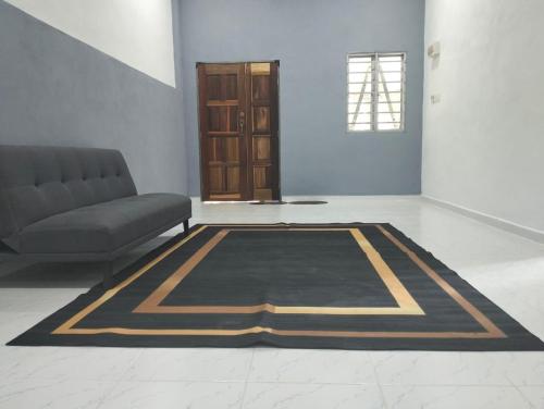 een woonkamer met een bank en een tapijt bij MTF Homestay in Baling