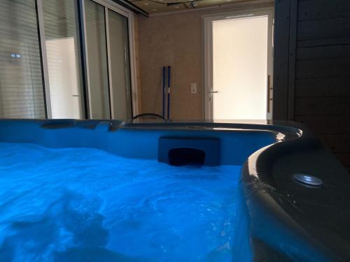 une grande baignoire bleue dans une salle de bain avec dans l'établissement Ô songes de Saxel, à Saxel