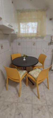 a table and chairs in a kitchen with a table and chairs at Valloris Apartments in Hévíz