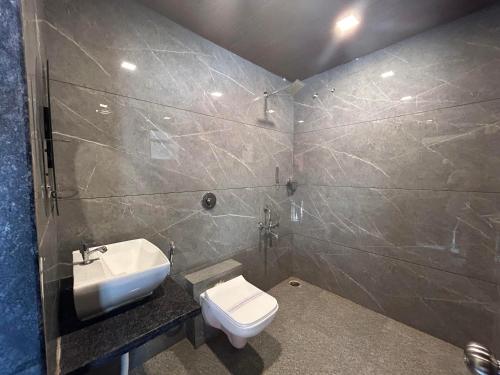 bagno con servizi igienici bianchi e lavandino di Trattino Resorts a Panchgani
