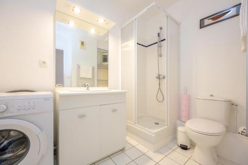 een witte badkamer met een toilet en een douche bij Noz Vat - Appt pour 2 avec balcon in Plouha