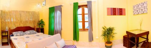 a bedroom with green and yellow walls and a bed at La Casa Nostra in Luang Prabang