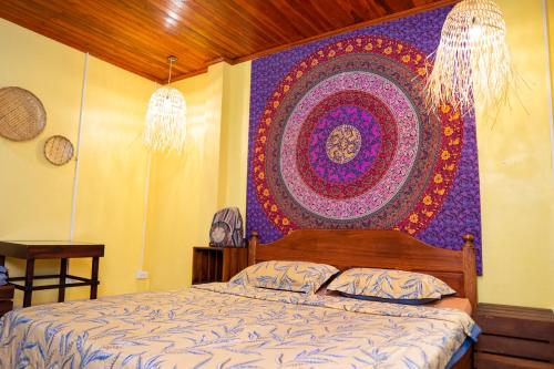 a bedroom with a bed with a large tapestry on the wall at La Casa Nostra in Luang Prabang