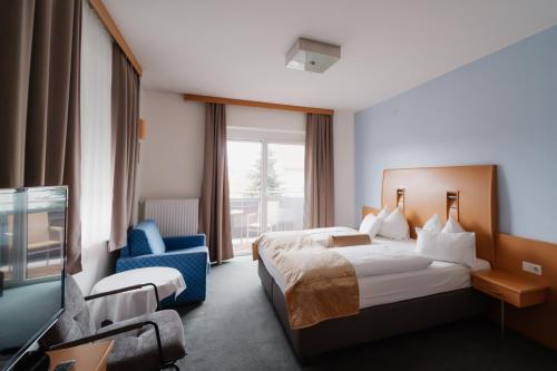 um quarto de hotel com uma cama e uma televisão em Seminar & Urlaubshotel Oststeirischer Hof Söchau em Söchau