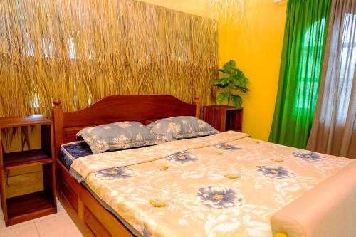 a bedroom with a bed with blue flowers on it at La Casa Nostra in Luang Prabang