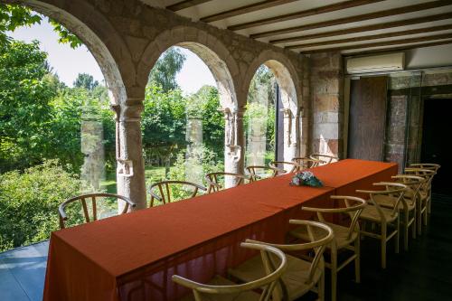 a red table and chairs in a room with windows at Hotel Boutique El Convento de Mave in Santa María de Mave