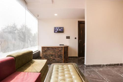 a living room with a couch and a large window at OYO Flagship Star Stay in New Delhi