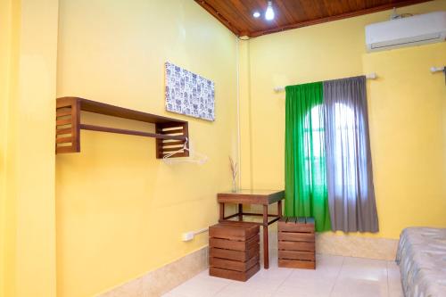 a room with a bed and a desk and a window at La Casa Nostra in Luang Prabang