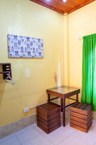 a room with a table and a green curtain at La Casa Nostra in Luang Prabang