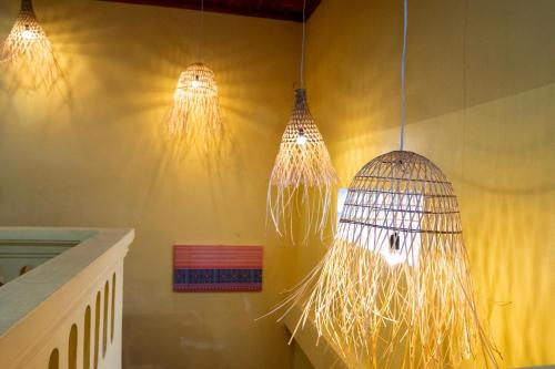 a room with three chandeliers and a bird cage at La Casa Nostra in Luang Prabang