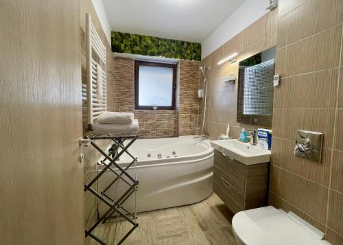 a bathroom with a tub and a toilet and a sink at Snagov Lake Apartments - Club Lac Snagov in Turbaţi