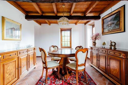 Montecalvo Versiggia的住宿－Villa Teresa - Villa & Piscina immersi nel vigneto!，一间带木桌和椅子的用餐室