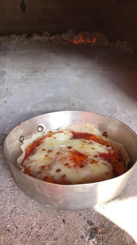 a metal bowl of food sitting on the ground at Villa Teresa - Villa & Piscina immersi nel vigneto! in Montecalvo Versiggia
