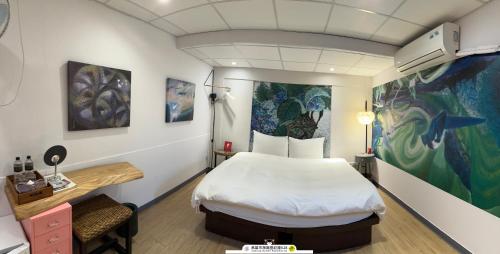 a room with a bed and a painting on the wall at ArtHome藝宿家客棧 in Kaohsiung