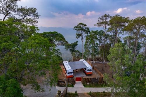 Kampong Seila的住宿－Romhaey Kirirom Resort，两辆卡车停在树旁的停车场