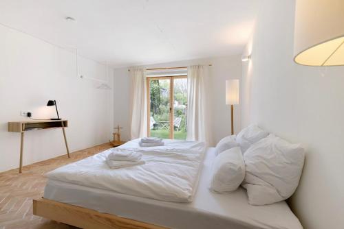 uma cama branca num quarto com uma janela em Im Gräbele em Rosenfeld