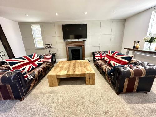 a living room with two couches and a coffee table at 5 Bed Luxury House with Swimming pool in Chepstow