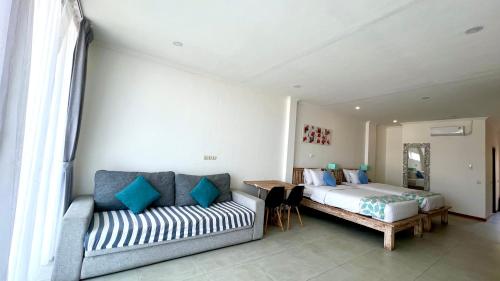 a bedroom with a bed and a couch at Komodo Suites Downtown in Labuan Bajo