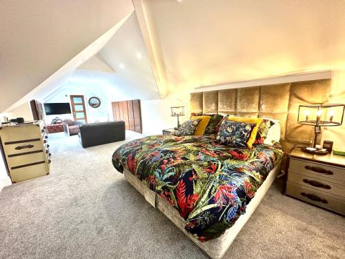 a bedroom with a large bed and a dresser at 5 Bed Luxury House with Swimming pool in Chepstow