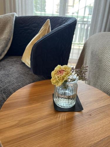 a vase of flowers on a coffee table on a couch at Hotel Garni Villa Rosengarten in Überlingen