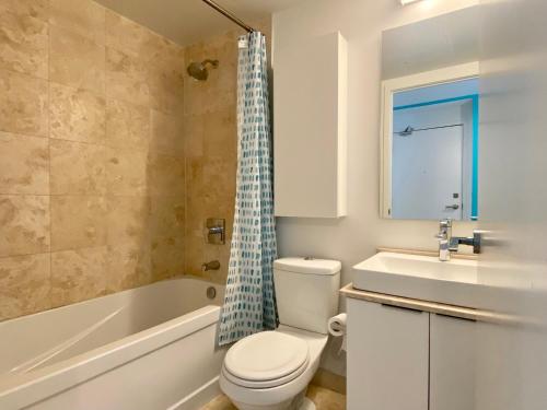 a bathroom with a toilet and a tub and a sink at waterfront Executive INN in Toronto