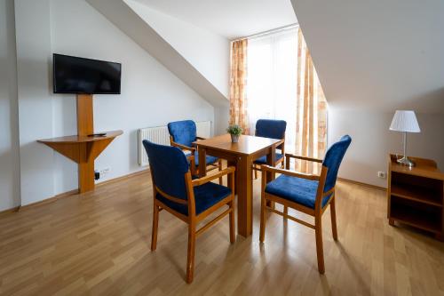a dining room with a table and blue chairs at Hotel Forrás Zalakaros in Zalakaros