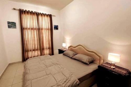 um quarto com uma cama grande e 2 mesas de cabeceira em Beautfiul Salalah Beach Apartment - Flat 404 em Salalah