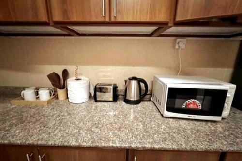 a kitchen counter with a toaster oven and a microwave at Beautiful Salalah Beach Apartments - 1 by Beautiful Salalah Tours in Salalah