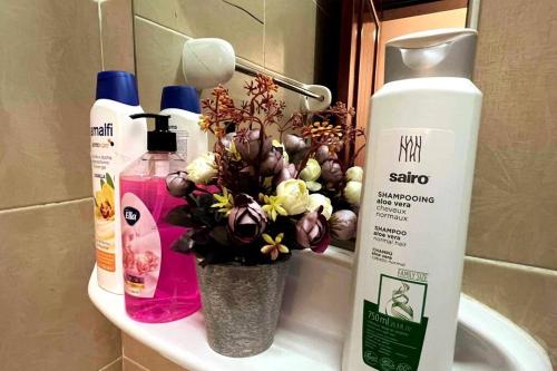 a bathroom sink with a vase of flowers on it at Beautiful Salalah Beach Apartments - 1 by Beautiful Salalah Tours in Salalah