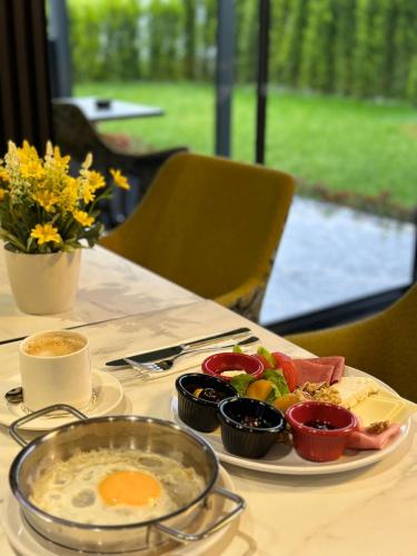 a plate of food on a table with eggs and vegetables at Gardenmode Airport Hotel in Taşoluk