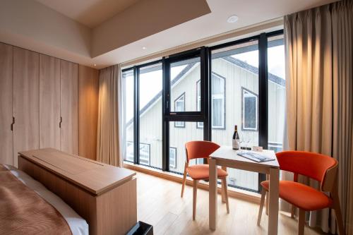 1 dormitorio con 1 cama, mesa y sillas en Niseko Kyo en Niseko