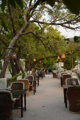 a row of tables and chairs under a tree at Heli Pushkar in Pushkar
