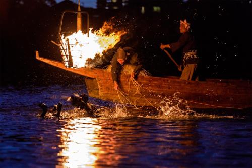 a group of people in a boat with fire at Inuyama City Hotel in Inuyama