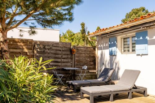 a patio with two chairs and a table and a fence at Maison de pêcheur au calme in La Faute-sur-Mer