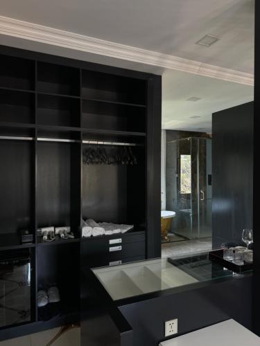 a black bathroom with a sink and a mirror at DNA Villa Space in Buôn Dhă Prŏng