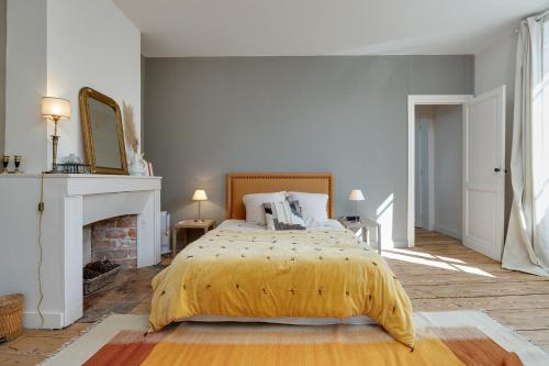 une chambre avec un lit et une cheminée dans l'établissement Maison de maître proche Bordeaux, à Carignan