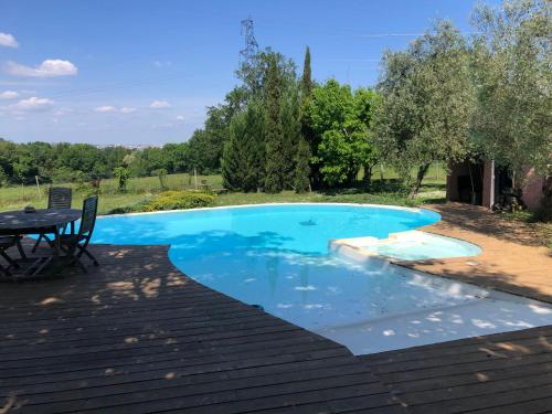 une piscine bleue avec une table et une terrasse dans l'établissement Maison de maître proche Bordeaux, à Carignan