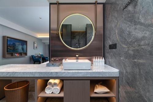 uma casa de banho com um lavatório e um espelho em Liz Hotel Maoming Dianbai em Maoming