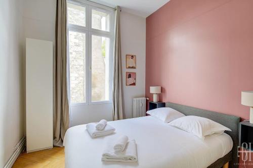 une chambre avec un lit blanc avec des serviettes dessus dans l'établissement L'albizia / Halles De Tours, à Tours