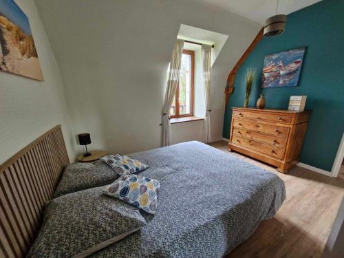 a bedroom with a bed and a dresser and a window at Le Grand Domaine du Rocher in Bonnemain