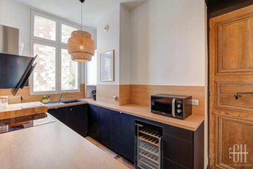 une cuisine avec un four micro-ondes assis sur un comptoir dans l'établissement L'albizia / Halles De Tours, à Tours