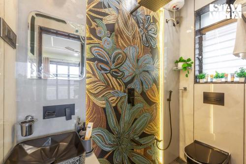 Un baño con ducha con un cuadro de pavo real en la pared. en StayVista's Cosmo Zen - Mountain-view villa with Pool, Jacuzzi, and Indoor & Outdoor activities, en Lonavala