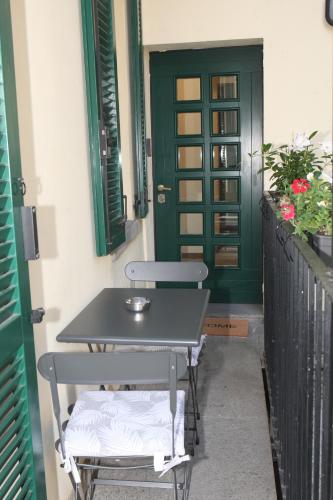 Ein Tisch und zwei Stühle vor einer grünen Tür in der Unterkunft JB in Como in Como