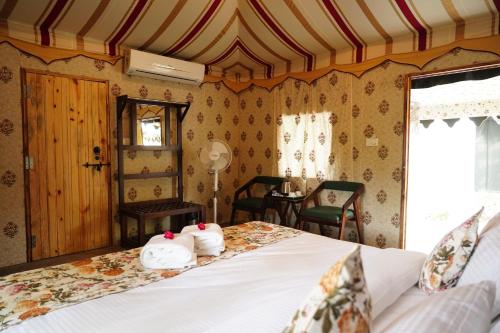 a bedroom with a bed with towels on it at Heli Pushkar in Pushkar